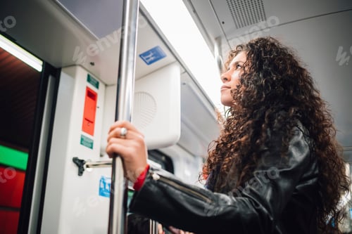 Preview: Mid adult woman with long curly hair on city subway train