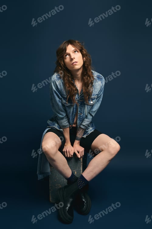 Preview: Fashion forward young man exudes confidence with unique style in modern studio setting