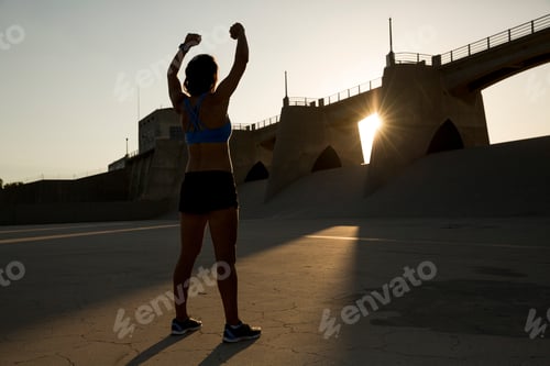 Preview: Triumphant runner celebrating a great workout at sunset