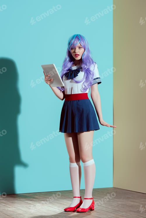 Preview: stylish girl with open mouth holding digital tablet and looking at camera in studio