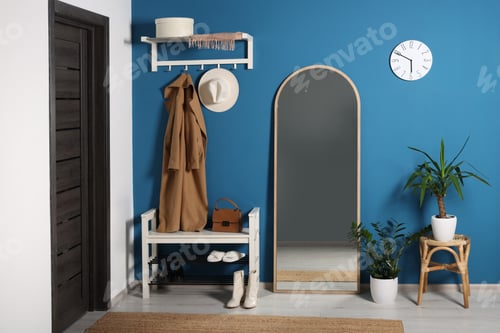 Preview: Stylish hallway with shoe storage bench and mirror near blue wall. Interior design