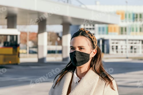 Preview: Front view of confident Young woman with face mask at a bus station in city