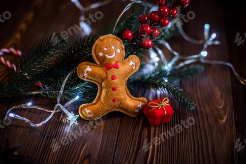 Preview: gingerbread Man on a vintage wooden table. Celebrating Christmas in a village house with garland