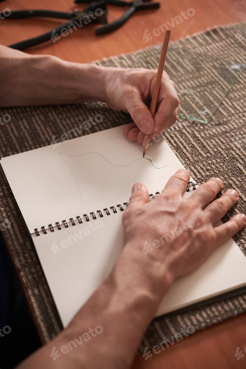 Preview: Man drawing sketch in notebook