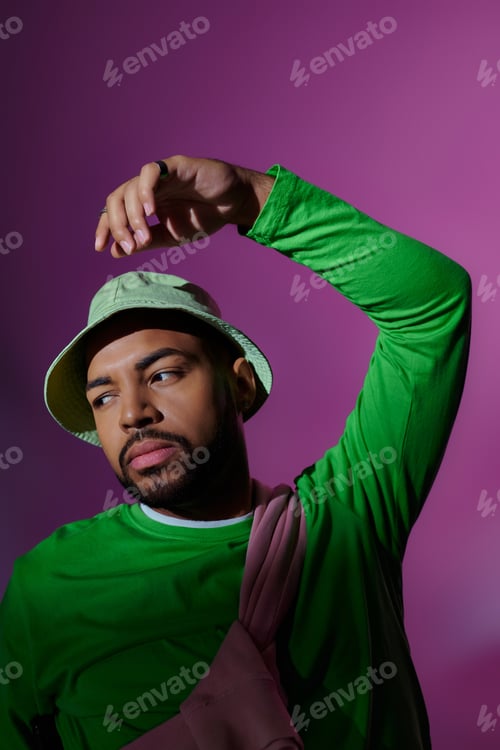 Preview: young bearded male model in stylish casual attire posing on purple backdrop, fashion concept