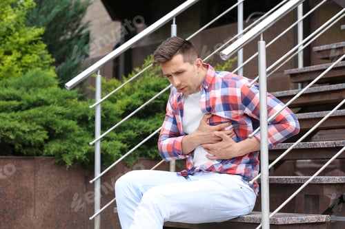 Preview: Young man having chest pain outdoors. Heart attack