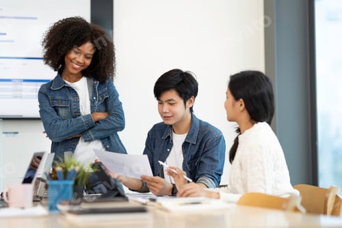 Preview: A happy Afro-American and multi-ethnic business men and women working together online on laptops in