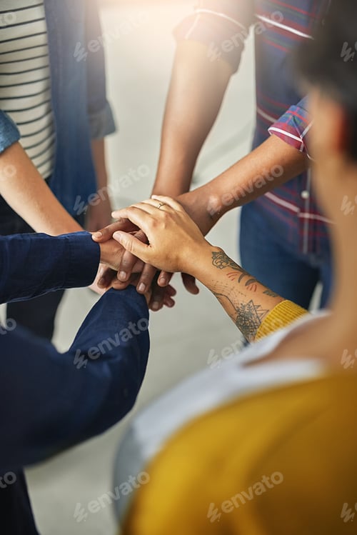Preview: Shot of a team of unidentifiable creatives piling their hands together in the office