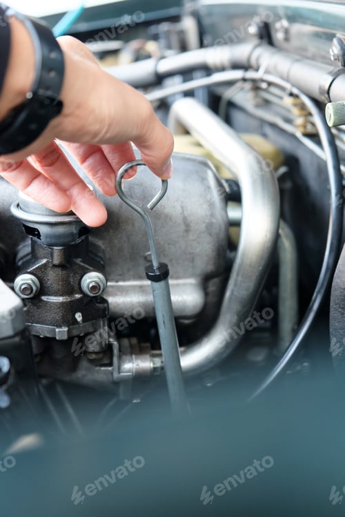 Preview: Image of a car mechanic checking the oil engine level.