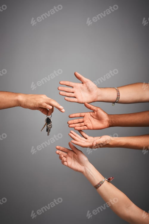 Preview: Studio shot of unidentifiable hands reaching for a set of keys against a gray background