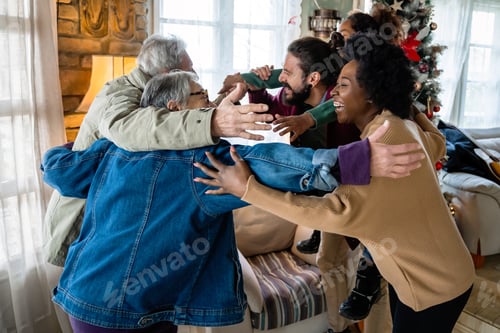 Preview: Excited multiethnic family greeting grandparents on Christmas Day. Multi-generational happy family