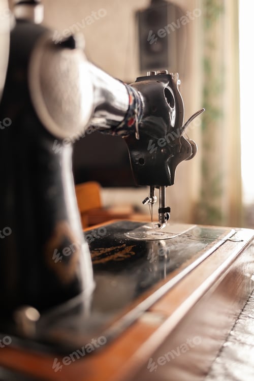 Preview: Old sewing machine stands on the table at home ready to work and sew.