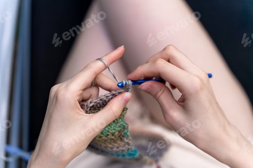 Preview: Girl crocheting a warm scarf. Top view