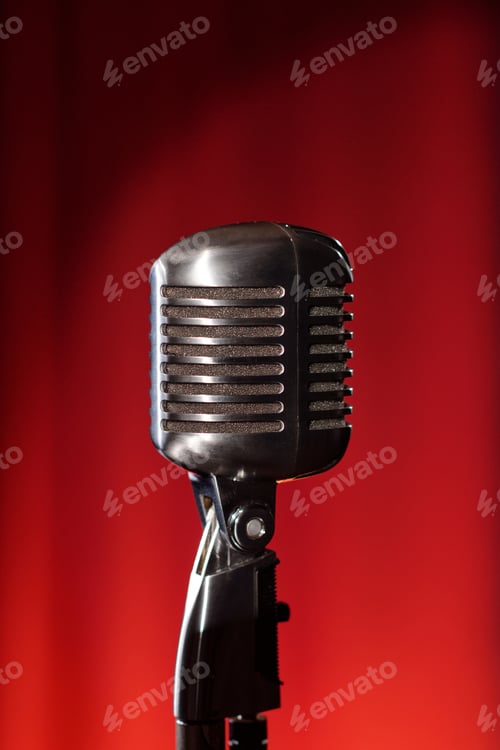 Preview: Vintage Microphone Standing Against Red Background in Jazz Performance Setting