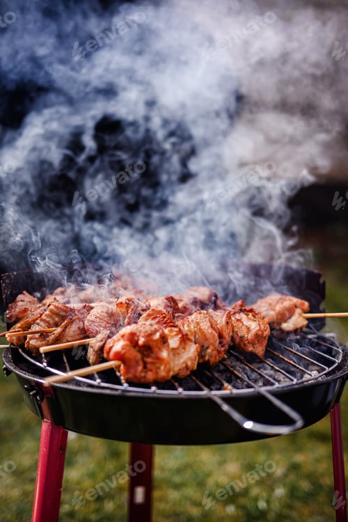 Preview: Grilled Meat Skewers Smoking on Charcoal BBQ Grill