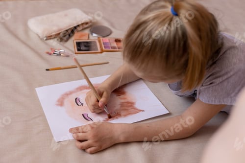 Preview: A small child girl draws a portrait with her mother's cosmetics.