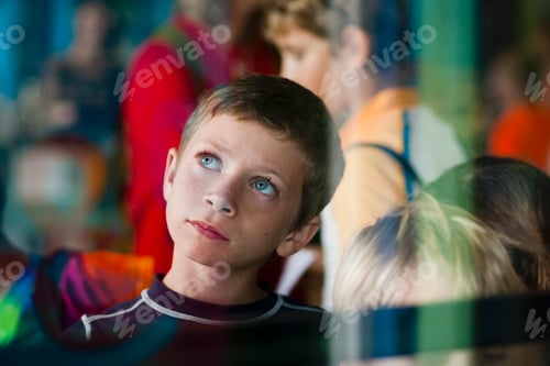 Preview: View through glass of young boy on outing looking up thoughtfully