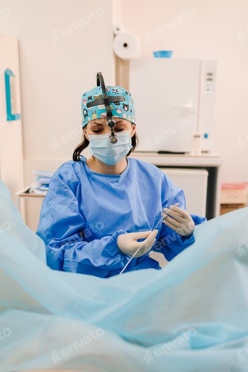 Preview: Woman Surgeon in Mask Holds Medical Device