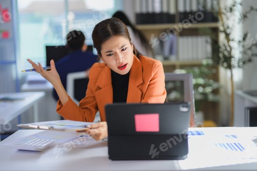 Preview: Asian businesswoman expressing frustration during video conference meeting