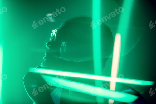 Preview: Cinematic portrait of handsome young man in neon lighted room, stylish musician