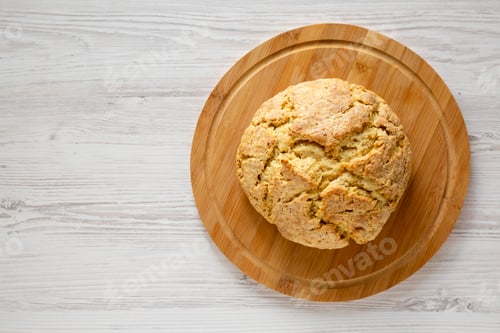 Preview: Homemade Irish Soda Bread on a bamboo board on a white wooden background, top view. Flat lay