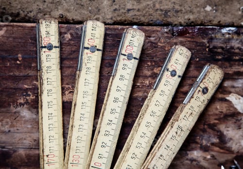 Preview: An old folding ruler sprawled on a worn wooden surface.