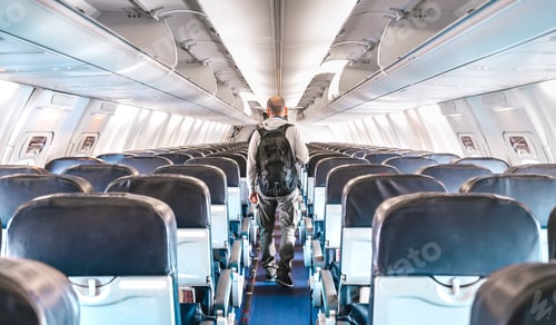 Preview: Inside view of commercial airplane with lonely man traveler