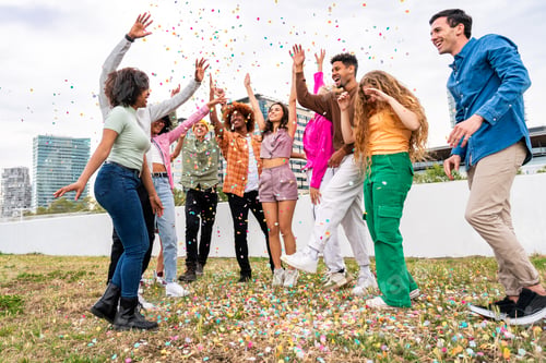 Preview: Happy playful multiethnic group of young friends bonding outdoors