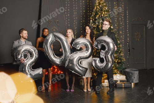 Preview: Male and female friends in standing with balloons 2023 for New Year's celebration