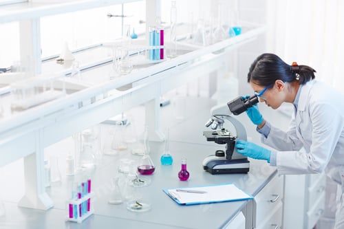 Woman Scientist Working With Microscope In Lab