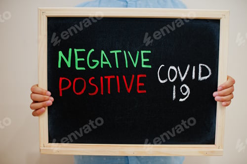 Preview: Negative or positive test Covid-19. Coronavirus concept. Boy hold inscription on the board.