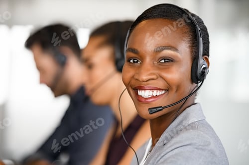 Preview: Black mature customer service woman on call with big smile