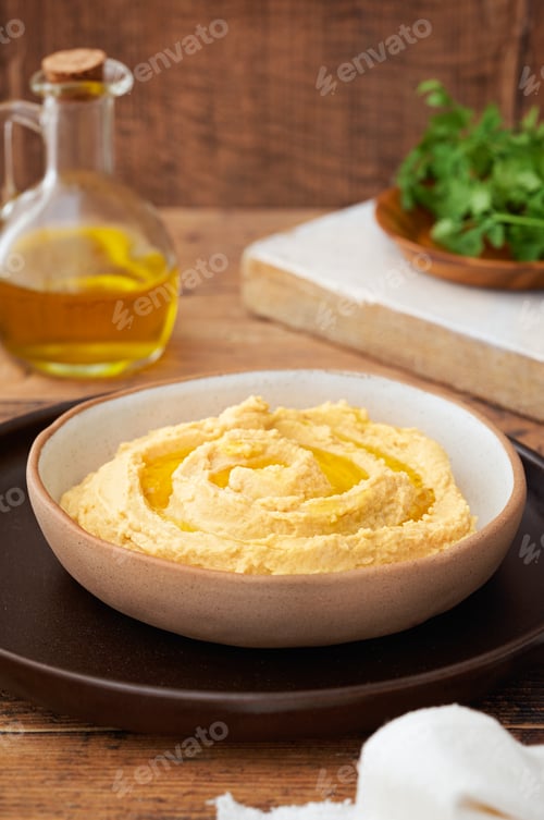 Preview: Homemade hummus with bread sticks and parsley on wooden background.