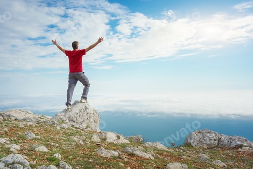 Preview: Man on sea cliff edge and blue sky at spring day.