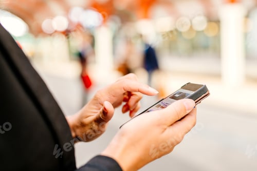 Preview: Midsection of businesswoman using smart phone at railroad station