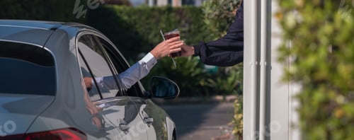 Preview: Hand Man in car receiving coffee in drive thru fast food restaurant.