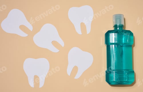 Preview: Mouthwash and paper cut out teeth on beige background, oral hygiene