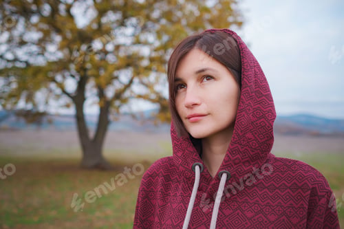 Preview: Portrait of a young woman in hoodie in the nature