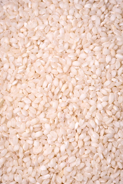 Preview: Large grains of uncooked white rice in a ceramic bowl