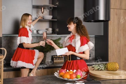 Preview: Cheerful woman takes glasses from kitchen cabinet