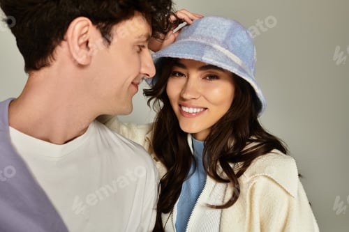 Preview: Young and stylish couple enjoying a playful moment in fashionable outfits