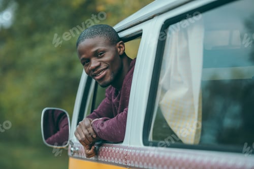 Preview: handsome smiling african american man sitting in retro styled minivan