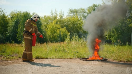 Preview: Fireman in helmet and protective uniform extinguishing the fire that bursting out from under the