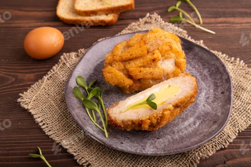 Preview: Chicken Schnitzel on gray plate with microgreen on brown wooden background