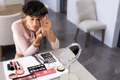 Preview: Applying eyeliner, transgender transgender woman using makeup tools at home vanity table