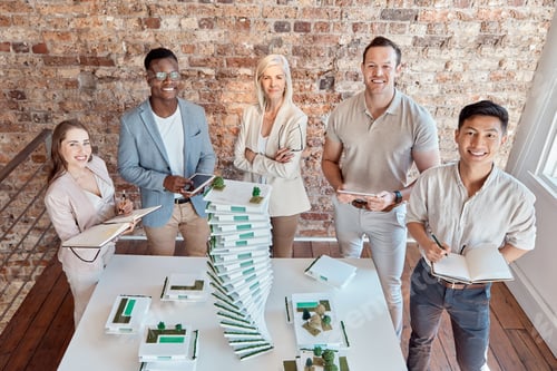 Preview: Group of diverse architects discussing plans, blueprints and schematics during a meeting in their o