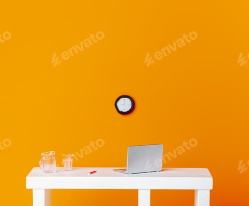 Preview: miniature figurines laptop and glass of water on a table with clock on orange background