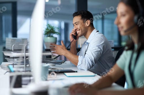 Preview: Shot of a young man answering the phone while working in a modern call centre