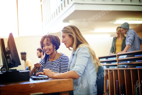 Preview: Shot of two university students working together on a computer in the library at campus