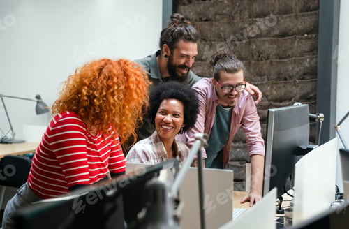 Preview: Smiling group of diverse businesspeople going over paperwork together, working in corporate office